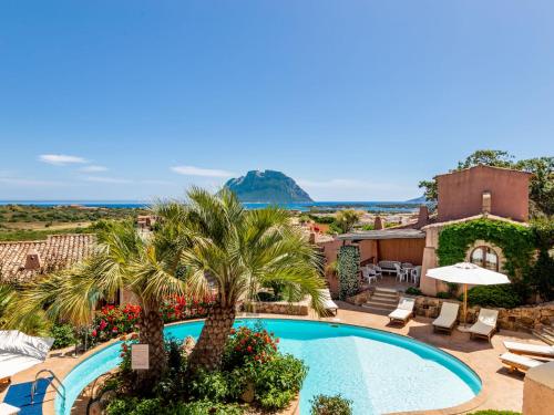a resort with a swimming pool and palm trees at Holiday Home Corbezzolo 9 - Vista Village by Interhome in Porto San Paolo