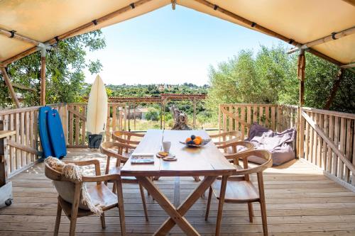 
a picnic table with chairs and umbrellas at Casa Tuia Resort in Carvoeiro
