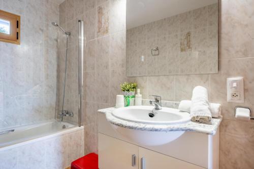 a bathroom with a sink and a shower and a tub at Can grau petit in Sencelles