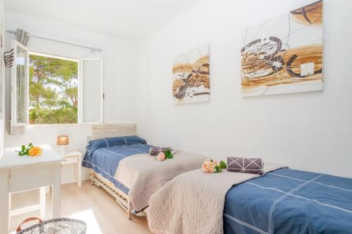 a bedroom with two beds and a window at Pregonda 13 Menorca in Son Parc
