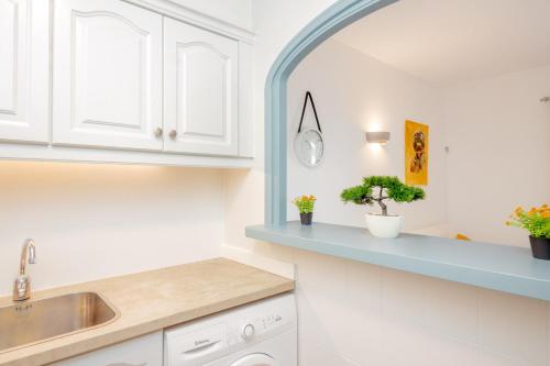 uma cozinha com armários brancos e um balcão azul em Pregonda 13 Menorca em Son Parc