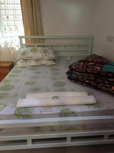 a bedroom with a bed with pillows on it at WEST ORANGE LODGE in Moshi
