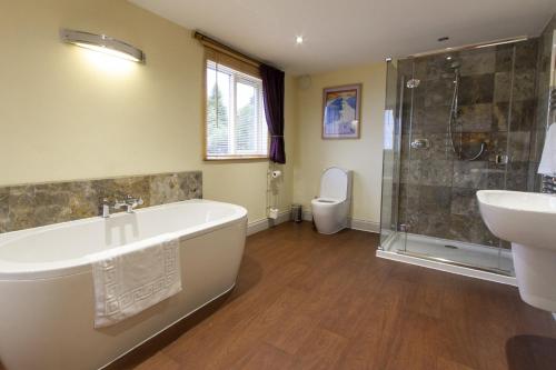 a bathroom with a tub and a sink and a toilet at The Lookout Keswick in Keswick