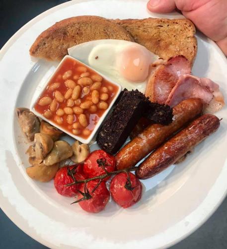 a plate of breakfast food with eggs bacon beans and toast at The Pheasant Inn in Grange Over Sands