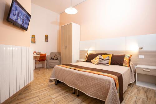 a bedroom with a bed and a tv on the wall at Trapani Home in Trapani
