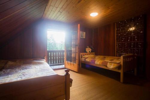 Habitación con 2 camas y ventana en una cabaña en Cottage in the woods - Lake Bohinj en Bohinj