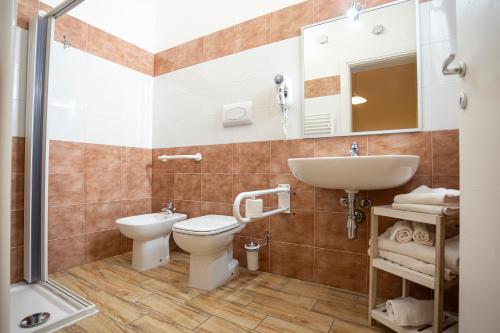 a bathroom with a toilet and a sink and a shower at Trapani Home in Trapani