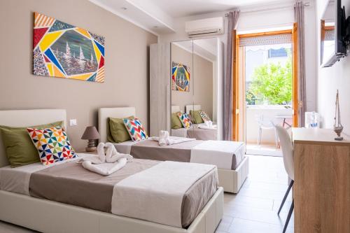 1 Schlafzimmer mit 2 Betten, einem Tisch und einem Fenster in der Unterkunft Vele d'Otranto B&B in Otranto