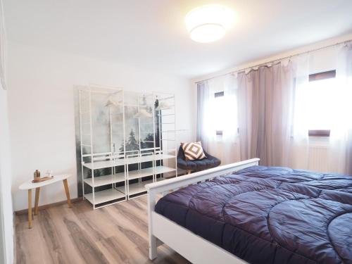 1 dormitorio con 1 cama, 1 silla y 1 ventana en Ferienhaus im Weindorf, en Kappelrodeck