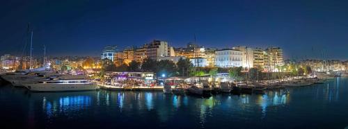 Scorpios Sea Side Hotel في بيرايوس: مجموعة من القوارب رست في الميناء في الليل