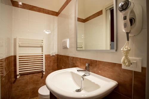 a bathroom with a sink and a mirror and a toilet at Trapani Home in Trapani