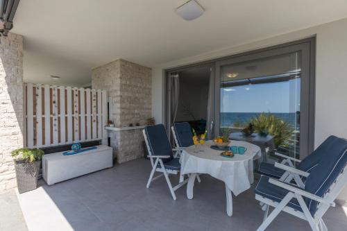 a patio with a table and chairs and a view of the ocean at Villa Lucia Umag in Umag