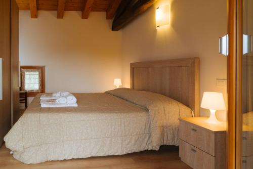 a bedroom with a bed with towels on it at Albergo Diffuso Polcenigo C. Zoldan in Polcenigo