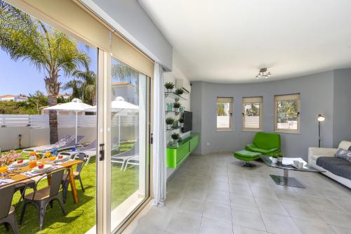 a living room with a couch and a table and chairs at Protaras Palm Villa 54 in Protaras