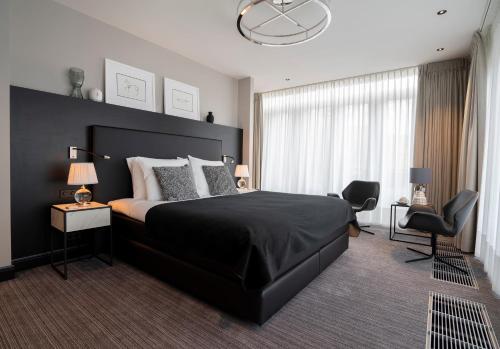 a bedroom with a large bed with a black headboard at Poorter Boutique Hotel Brielle in Brielle