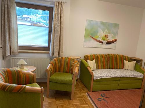a living room with two chairs and a couch and a window at Landhaus Appartement Kofler Ferienwohnungen,Zimmer in Maurach