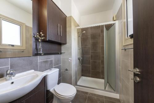 a bathroom with a toilet and a sink and a shower at Protaras Palm Villa 54 in Protaras