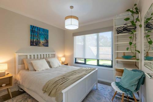 - une chambre avec un lit blanc et une fenêtre dans l'établissement Pine Beach Guest House in the Heart of Balnarring, à Balnarring