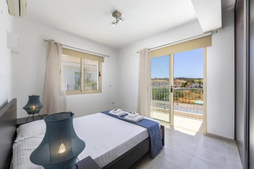 a bedroom with a bed and a large window at Protaras Palm Villa 54 in Protaras