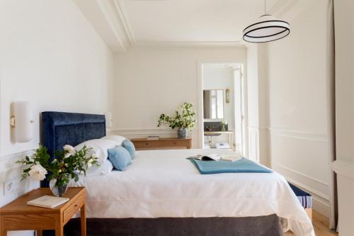 a bedroom with a large bed with a blue chair at Gran hotel Brillante in San Esteban de Pravia