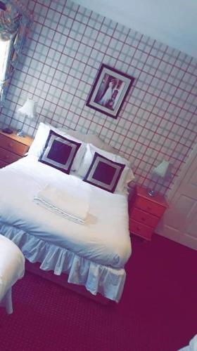 a bedroom with a bed and two pictures on the wall at Bertie Pontypridd in Trehafod