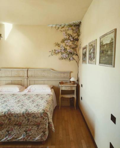 a bedroom with two beds and a table with a tree on the wall at B&B Casa Camilla in Padova