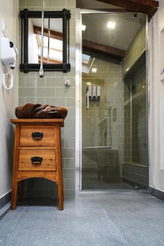 a bathroom with a shower with a wooden dresser and a sink at Vila Montana Valiug in Văliug