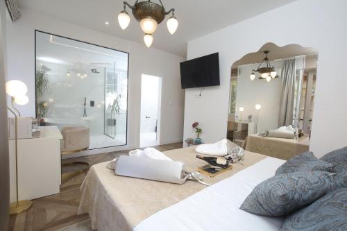 a bedroom with a large mirror and a white bed at Garden Luxury Rooms in Split