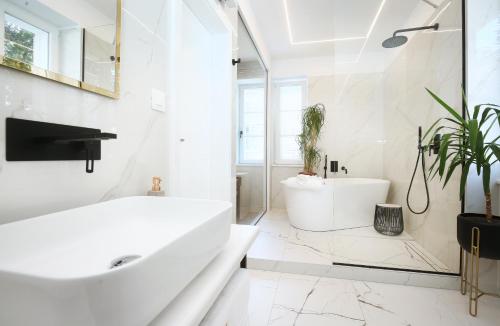 a white bathroom with a tub and a sink at Garden Luxury Rooms in Split