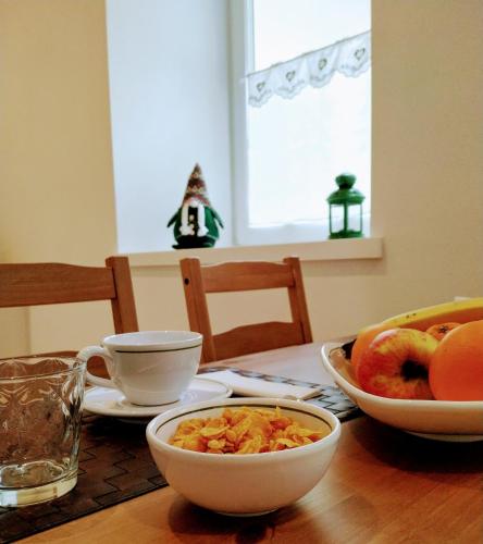 a wooden table with bowls of cereal and fruit on it at Le Bifore in valle in Predazzo