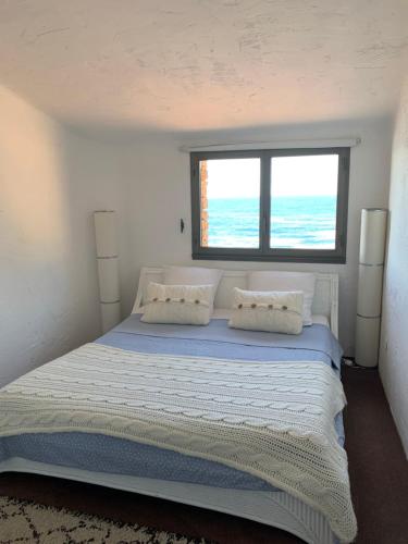een slaapkamer met een groot bed en een raam bij La Gavaresse in Carqueiranne