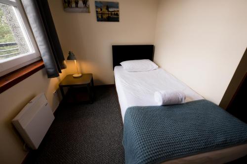 a small bedroom with a bed and a window at Bank Street Lodge in Fort William