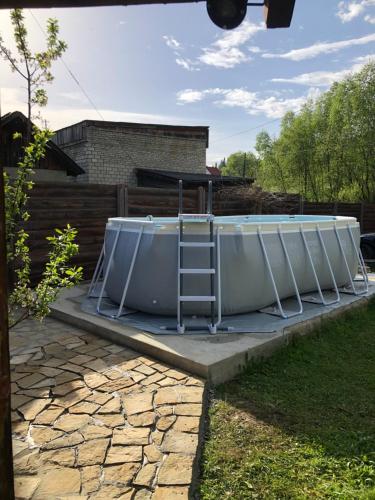 a bath tub sitting on a patio with a ladder at "Будиночок гедоніста" in Tukhlya
