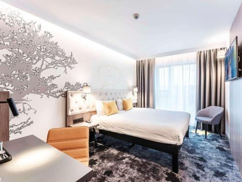 ルブリンにあるibis Styles Lublin Stare Miastoのベッドとデスクが備わるホテルルームです。