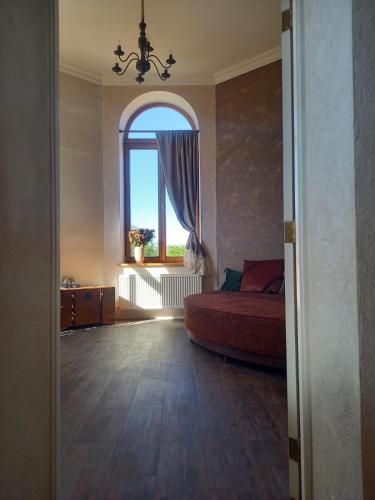 a bedroom with a bed and a large window at Vintage Rooms in Kuldīga