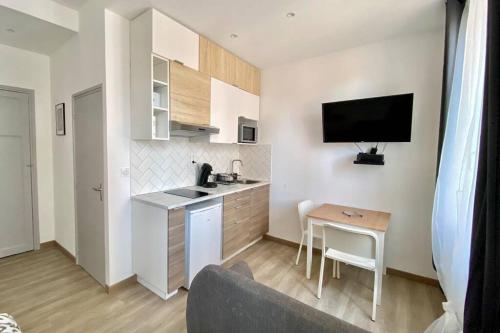 - une cuisine avec une table et une télévision dans la chambre dans l'établissement Studio cosy - Proche Gare & Centre ville, à Toulon