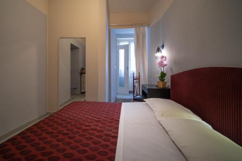 a bedroom with a large bed with a red bedspread at Hotel Italia in Turin