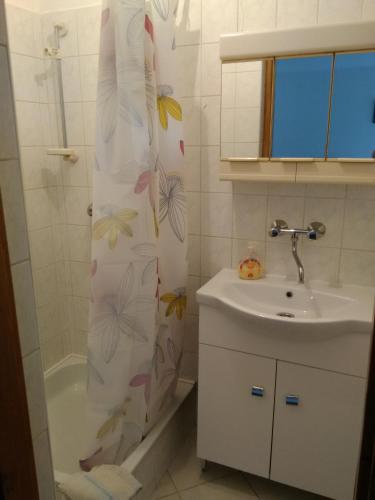 a bathroom with a sink and a shower curtain at Paprika vendégház in Harkány