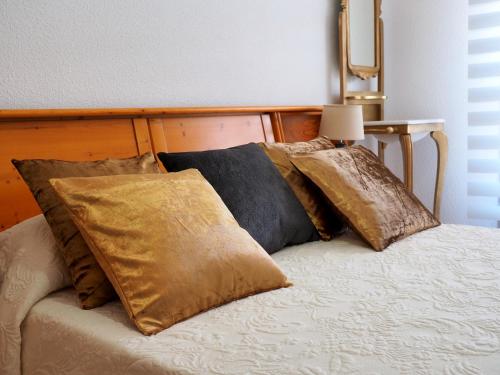 Una cama con cuatro almohadas encima. en Apartamento Turístico Duero Niño en Molinos de Duero