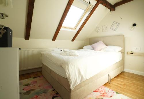 a bedroom with a large white bed with a window at Vila Montana Valiug in Văliug