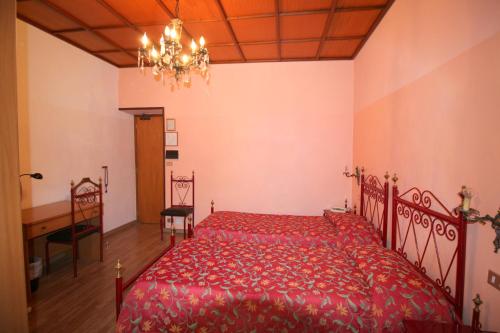 a bedroom with a red bed and a chandelier at Hotel Italia in Turin