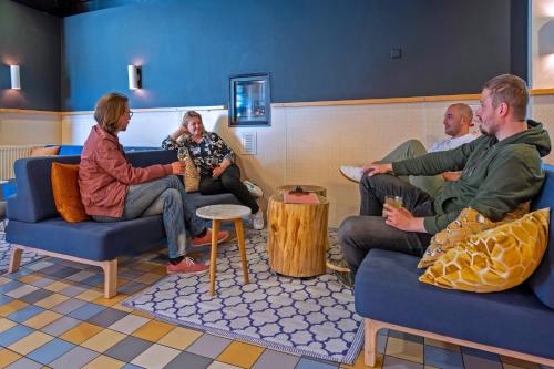 a group of people sitting in a waiting room at Stayokay Hostel Noordwijk in Noordwijk