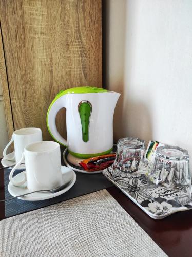 a table with a tea pot and cups on it at Attico Viva in Plitvička Jezera