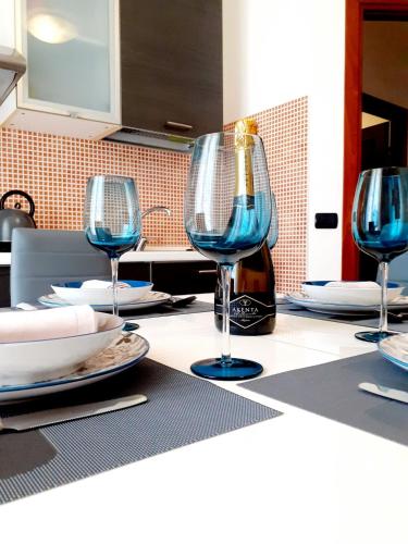 a table with three wine glasses and a bottle of wine at Clizia Apartment in Alghero