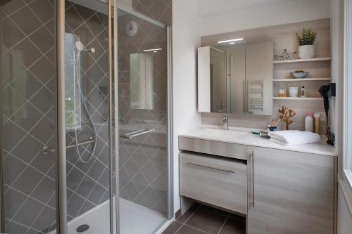 La salle de bains est pourvue d'une douche et d'un lavabo. dans l'établissement DOMITYS LA BADIANE, à Marseille