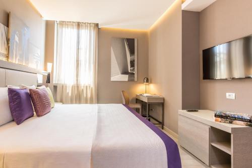 ein Hotelzimmer mit einem großen Bett und einem TV in der Unterkunft Orazio Palace Hotel in Rom