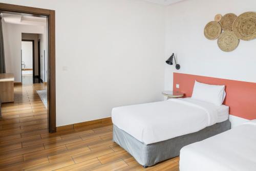 a bedroom with two beds and a mirror at Dara Qurtubah Hotel in Riyadh