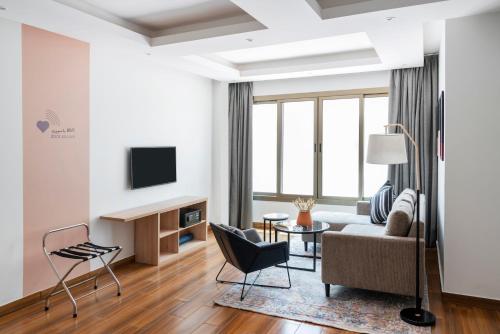 a living room with a couch and a tv at Dara Qurtubah Hotel in Riyadh