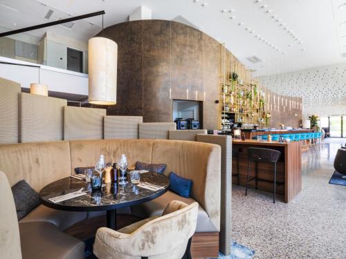un restaurante con mesa y sillas y un bar en Crowne Plaza - Nice - Grand Arenas, an IHG Hotel, en Niza