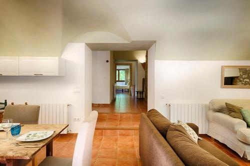 a living room with a couch and a table at Can Cruanyes in Sales del Llierca